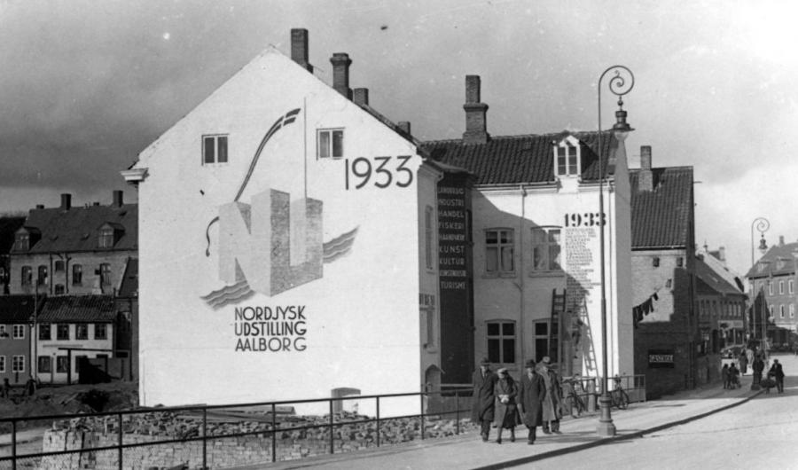 Gammelt foto med gavl med reklame for Nordjysk Udstilling 1933