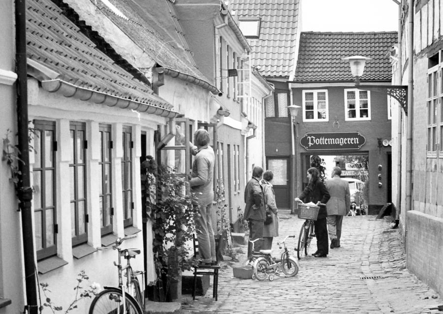Sort/hvidt foto af mennesker i Hjelmerstald-kvarteret. I baggrunden ses Pottemageren.