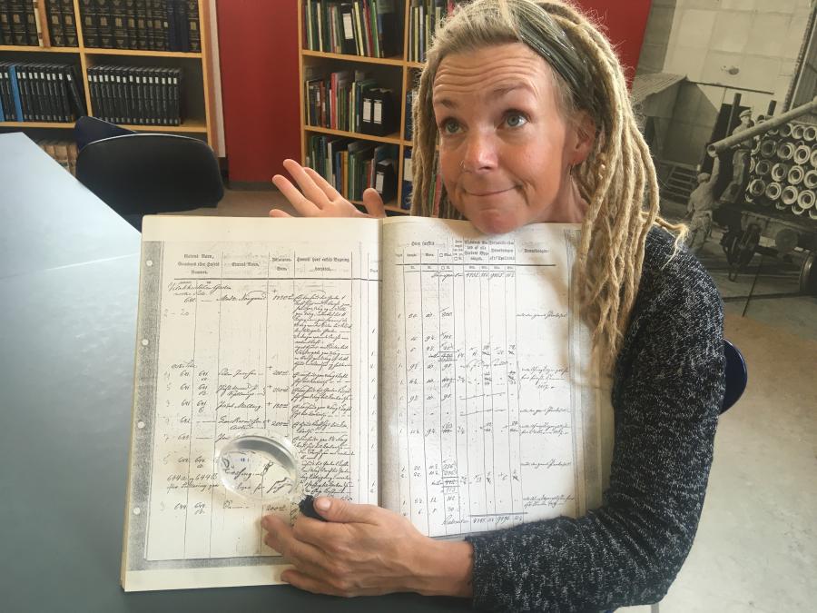Karina holder bog med gotisk skrift i favnen