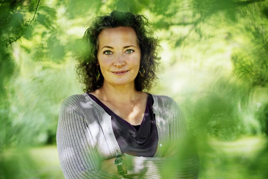 Anne-Cathrine Riebnitzsky på baggrund af grønne blade