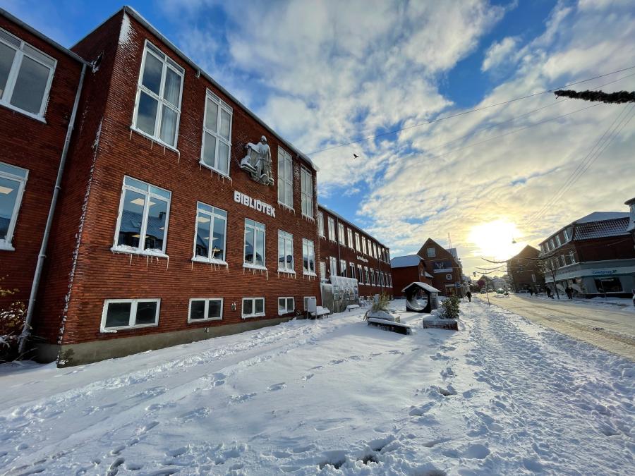 Vejgaard Bibliotek en dag med masser af sne på veje og stræder og med blå himmel og solskin.