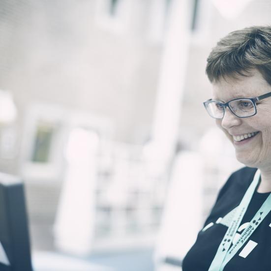 En bibliotekar står og smiler