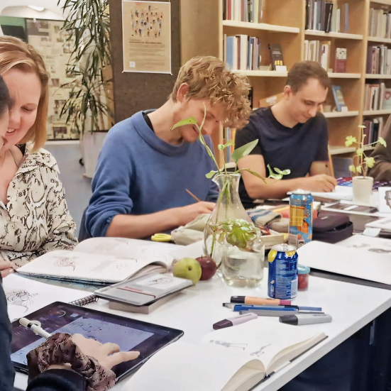 En gruppe mennesker sidder og tegner