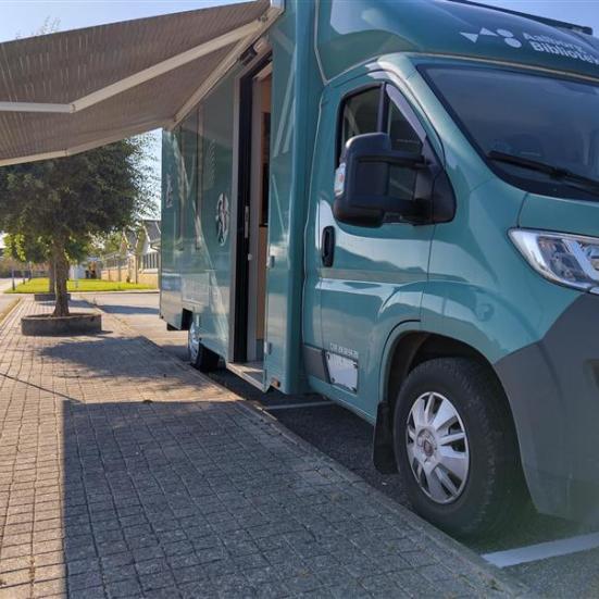 Bogbilen holder parkeret ved et fortov med markisen trukket ud.