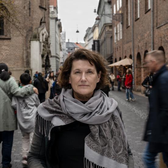 Portræt af Janne Teller. I baggrunden går en masse mennesker forbi.