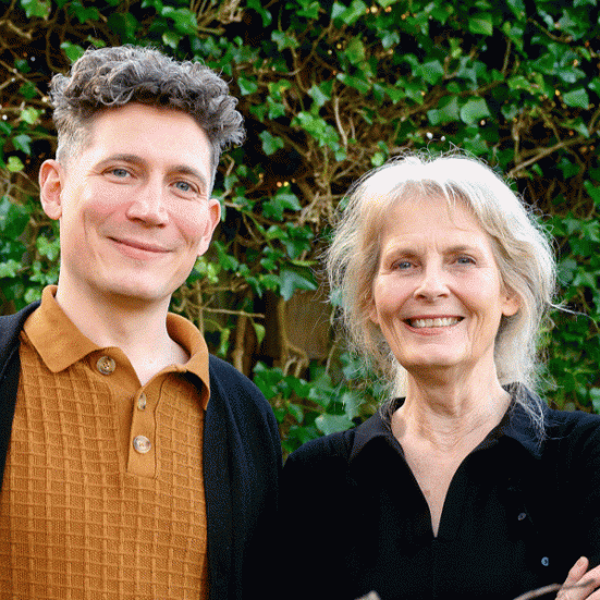 Psykolog Anne Knudsen og læge, sociolog og ph.d. Søren Valgreen Knudsen står foran en væg, der er bevokset med "arkitektens trøst".
