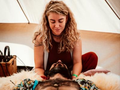 En person ligger i et telt, hvor en anden person er i gang med at lave psykomotorisk terapi