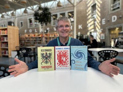 Erling sidder ved et hvidt bord på Hovedbiblioteket. På bordet har han sat alle tre romaner, som er omtalt i denne artikel, foran sig. De står alle med forsiderne frem og Erling laver en præsenterende gestus mod dem. Erling smiler og baggrunden, der viser biblioteksrummet med fyldte bogreoler, er let slørret.