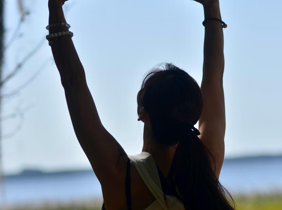 En person rækker hænderne op over hovedet.